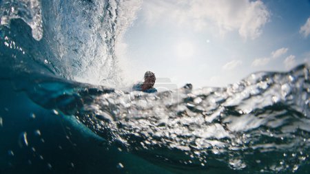 Photo for Surfer rides the wave. Young man surfs the ocean wave in the Maldives, splitted above and underwater view - Royalty Free Image
