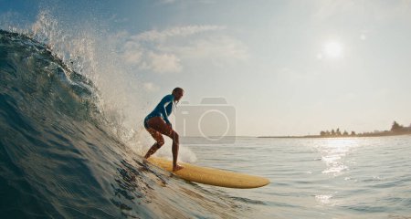 Mujer delgada surfista monta la ola. Mujer surfea la ola oceánica en las Maldivas en longboard amarillo