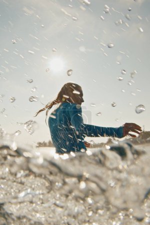 Foto de La mujer surfista monta la ola. Mujer surfea la ola oceánica en las Maldivas con salpicaduras - Imagen libre de derechos