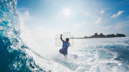 Foto de La chica surfista monta la ola. Mujer surfea la ola oceánica en las Maldivas y cae - Imagen libre de derechos