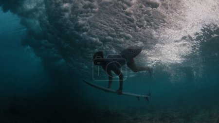 Foto de Surfista hace buceo de pato para pasar la ola - Imagen libre de derechos
