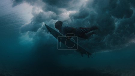 Foto de Surfista hace buceo de pato para pasar la ola - Imagen libre de derechos
