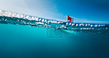 Photo for Woman surfer in red suit surf the wave on the yellow longboard in the Maldives - Royalty Free Image