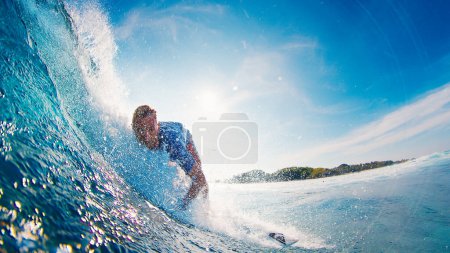 Téléchargez les photos : Surfer surfe sur la vague dans l'eau bleue des Maldives - en image libre de droit