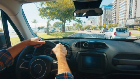 Téléchargez les photos : L'homme conduit la voiture dans une ville - en image libre de droit