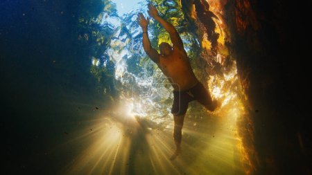 Foto de Joven inmersiones libres en el lago situado en un bosque - Imagen libre de derechos