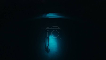 Foto de Freediver nada bajo el agua en la cueva. Hombre libre explora la cueva y nadar bajo el agua dentro de ella - Imagen libre de derechos