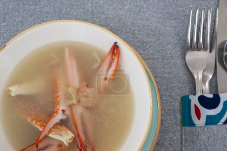 Foto de Primer plano de sopa de mariscos de cangrejo a la carta aperitivo comida de entrada en tazón con cubiertos en la mesa del restaurante - Imagen libre de derechos