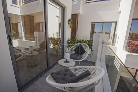 Téléchargez les photos : Meubles de terrasse d'un appartement de luxe dans une station tropicale avec table et chaises sur balcon - en image libre de droit