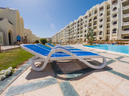 Téléchargez les photos : Grande piscine extérieure avec chaises longues dans un complexe hôtelier tropical de luxe - en image libre de droit