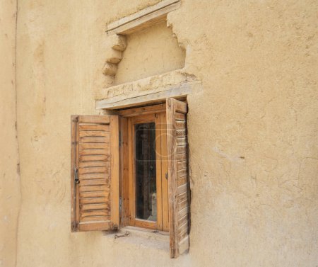 Téléchargez les photos : Vieille fenêtre rustique en bois avec volets en mur de brique de boue traditionnelle maison égyptienne - en image libre de droit