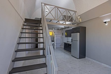 Téléchargez les photos : Décoration intérieure montrant la cuisine moderne et les appareils électroménagers dans le showroom appartement duplex de luxe avec escalier en bois - en image libre de droit