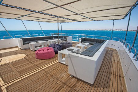 Photo for Teak sundeck of a large luxury motor yacht with chairs sofa table and tropical sea view background - Royalty Free Image