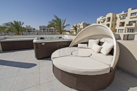 Téléchargez les photos : Terrasse sur le toit meubles de patio dans une villa de luxe dans une station balnéaire tropicale avec chaise longue et bain à remous - en image libre de droit