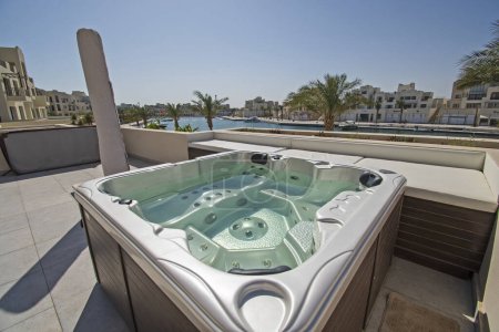Téléchargez les photos : Terrasse sur le toit meubles de patio dans une villa de vacances de luxe dans un complexe tropical avec bain à remous et vue sur la marina - en image libre de droit