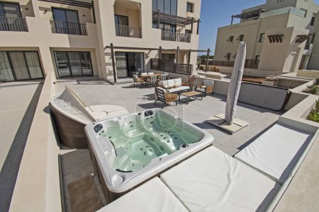 Téléchargez les photos : Terrasse sur le toit meubles de patio dans une villa de vacances de luxe dans un complexe tropical avec table et bain à remous - en image libre de droit