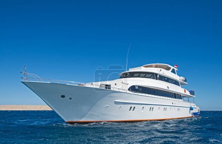 A large luxury private motor yacht under way sailing on tropical sea with bow wave