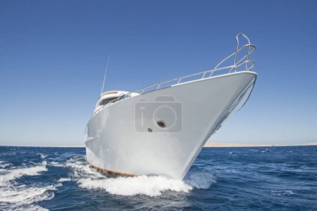 Bug einer großen privaten Luxus-Motorjacht unterwegs, die auf tropischem Meer mit Bugwelle segelt