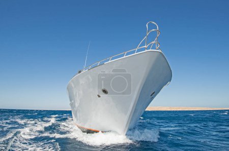 Téléchargez les photos : Arc d'un grand yacht à moteur privé de luxe en cours de navigation sur la mer tropicale avec vague d'arc - en image libre de droit