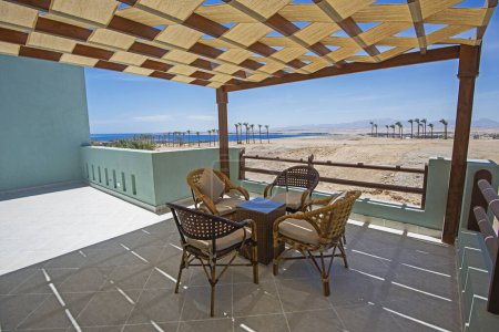 Dachterrasse einer Luxuswohnung im tropischen Resort mit Möbeln und Meerblick vom Balkon