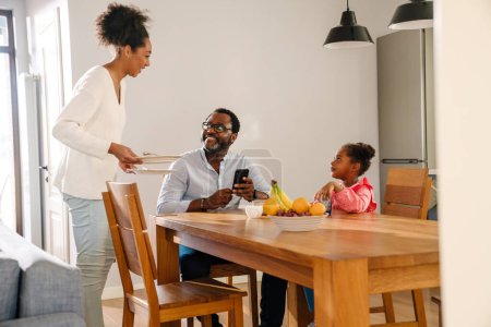 Photo for African american family woman and man with little daughter smiling and having breakfast at home - Royalty Free Image