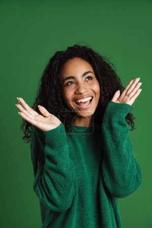 Photo for Young black woman wearing sweater laughing and gesturing isolated over green background - Royalty Free Image