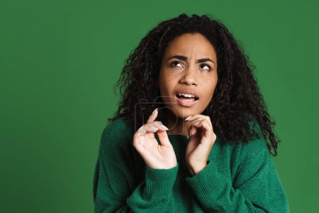 Photo for Young black woman frowning and gesturing at camera isolated over green background - Royalty Free Image