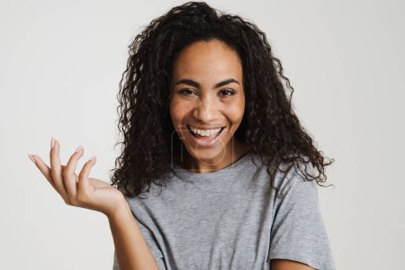 Photo for Young black woman with wavy hair laughing and holding copyspace isolated over white background - Royalty Free Image
