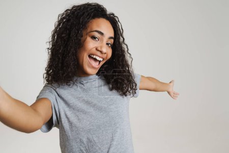 Téléchargez les photos : Young black woman showing copyspace while taking selfie photo isolated over white background - en image libre de droit