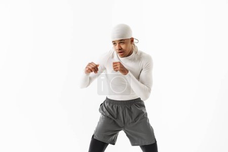 Téléchargez les photos : Jeune sportif portant la boxe bandana tout en travaillant isolé sur fond blanc - en image libre de droit