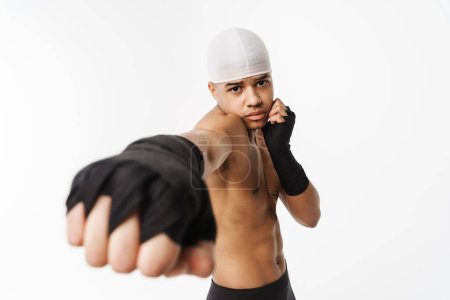 Téléchargez les photos : Jeune boxe sportive torse nu tout en travaillant isolé sur fond blanc - en image libre de droit