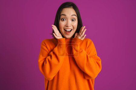 Photo for Young asian woman gesturing while expressing surprise at camera isolated over purple background - Royalty Free Image