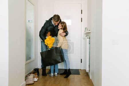 Téléchargez les photos : Heureuses sœurs adoptives rencontrant à la porte le père qui est rentré à la maison - en image libre de droit