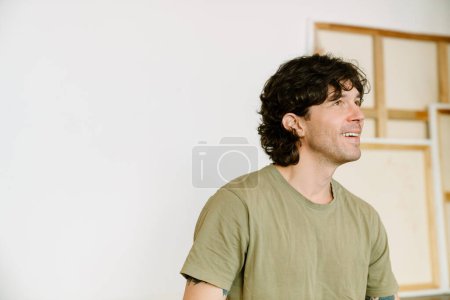 Téléchargez les photos : Homme blanc portant un t-shirt riant pendant la pratique du yoga à la maison - en image libre de droit