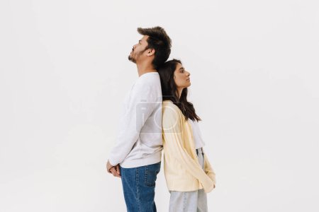 Téléchargez les photos : Est asiatique jeune homme et femme debout dos à dos isolé sur fond blanc - en image libre de droit