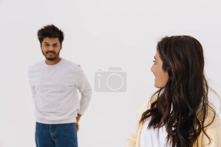Téléchargez les photos : Jeune couple indien se regardant tout en posant ensemble isolé sur fond blanc - en image libre de droit