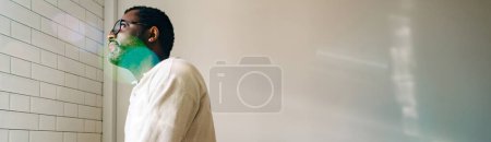 Photo for Mature african american man wearing eyeglasses standing over white wall at home - Royalty Free Image
