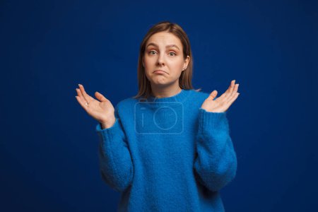 Photo for Young beautiful girl in blue sweater showing dont know gesture over isolated blue background - Royalty Free Image
