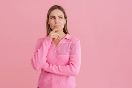 Téléchargez les photos : Jeune belle femme blanche portant chemise réfléchissant et regardant de côté debout isolé sur fond rose - en image libre de droit