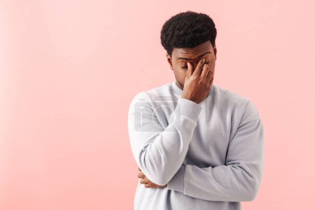 Photo for Black tired man rubbing his eyes while posing on camera isolated over pink background - Royalty Free Image