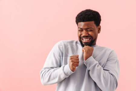 Photo for Black mid man with beard grimacing while posing on camera isolated over pink background - Royalty Free Image
