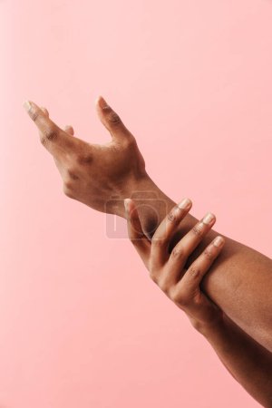 Téléchargez les photos : Photo de l'homme noir montrant ses mains sur l'appareil photo isolé sur fond rose - en image libre de droit