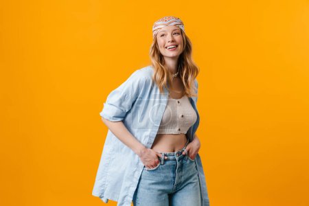 Photo for Young blonde woman wearing bandanna smiling and looking aside isolated over yellow background - Royalty Free Image