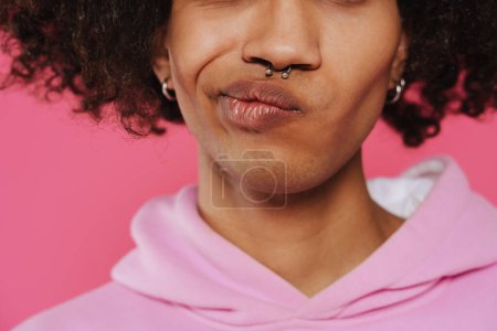 Photo for Young caribbean man with piercing grimacing at camera isolated over pink background - Royalty Free Image