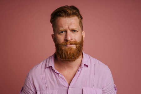 Photo for Ginger white man with beard frowning and looking at camera isolated over pink background - Royalty Free Image