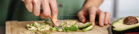 Photo for Caucasian woman preparing sandwich with avocado at home kitchen - Royalty Free Image