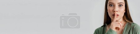 Téléchargez les photos : Tendu caucasien fille montrant silence geste à caméra isolé sur fond blanc - en image libre de droit