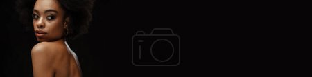Téléchargez les photos : Africaine américaine torse nu femme posant et regardant de côté isolé sur fond noir - en image libre de droit