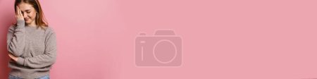 Téléchargez les photos : Jeune roux femme heureuse souriant et couvrant son visage isolé sur fond rose - en image libre de droit