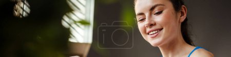 Photo for White young woman smiling while washing vegetables at home kitchen - Royalty Free Image